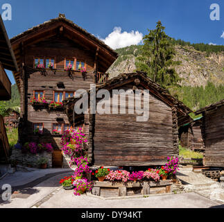 Antike alte Holzhäuser Chalets Stadt Dorf Blumen Sommer Berge Hügeln Evolene Val Hérens Wallis Wallis Schweiz Stockfoto