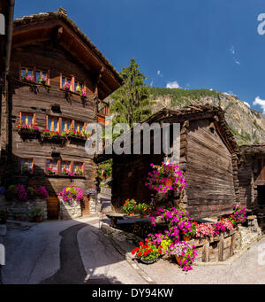 Antike alte Holzhäuser Chalets Stadt Dorf Blumen Sommer Berge Hügeln Evolene Val Hérens Wallis Wallis Schweiz Stockfoto