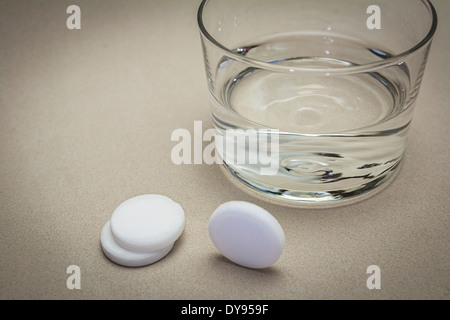 Brausetabletten und Glas mit Wasser Stockfoto