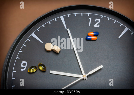 Konzept für Gesundheitswesen und Medizin, markiert eine Uhr die Zeit der Einnahme von Medikamenten Stockfoto