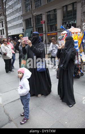 Komplett überdachte muslimische Frauen in Burkas Schnappschüsse auf der Tartan Day Parade in New York City. Stockfoto