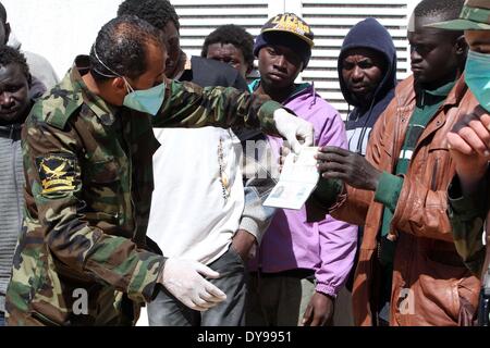 Tripoli, Libyen. 10. April 2014. Polizisten kontrollieren die Pässe der illegalen Einwanderer in Tripolis, Libyen, am 10. April 2014. Das libysche Innenministerium verhaftet 46 illegale Einwanderer während eine Marineoperation in internationalen Gewässern in der Nähe von Libyen. Bildnachweis: Hamza Türkei/Xinhua/Alamy Live-Nachrichten Stockfoto