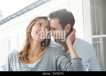 Paar Flüstern und lächelnd durch Fenster Stockfoto