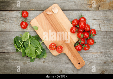 Cherry-Tomaten auf Messers Schneide an Bord über Holztisch Hintergrund Stockfoto