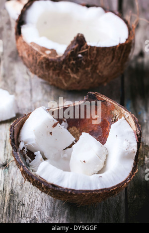 Zerbrochene Kokosnussschalen auf alten hölzernen Hintergrund Stockfoto