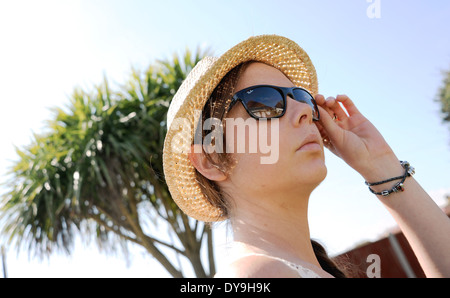 Junge Frau der 20er Jahre tragen Ray Ban Sonnenbrillen und Stroh Stil wirklich Hut Sommermode Foto von Simon Dack Stockfoto