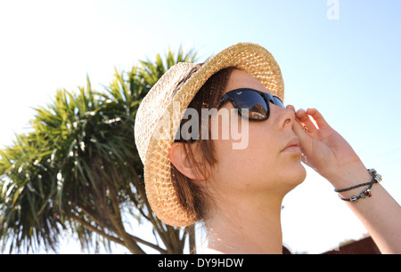 Junge Frau der 20er Jahre tragen Ray Ban Sonnenbrillen und Stroh Stil wirklich Hut Sommermode Foto von Simon Dack Stockfoto