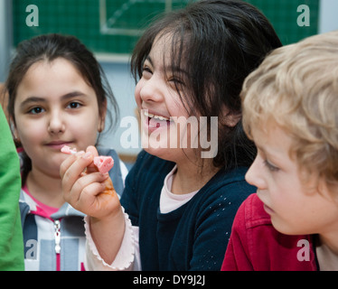 Nicht behinderte und behinderte Schüler (in diesem Fall ein Mädchen mit Down-Syndrom) lernen gemeinsam in der gleichen Klasse. Stockfoto