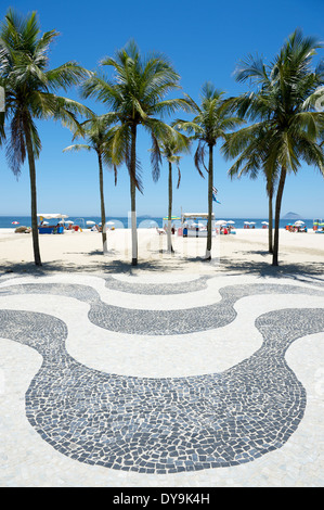 Kultige geschwungene Bürgersteig Fliesenmuster mit Palmen am Copacabana Strand Rio de Janeiro Brasilien Stockfoto