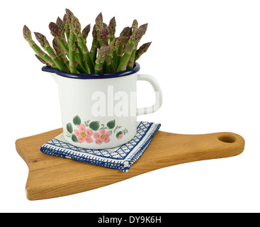 Bund grüner Spargel in Emaille-Topf, isoliert auf weiss. Stockfoto