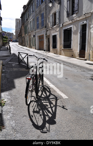 ein einzelnes Fahrrad zeigt Schatten, geparkt in verlassenen Straße in Arles Frankreich Stockfoto