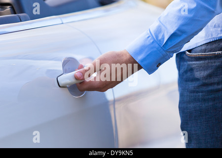Lateinamerikanische Fahranfänger seine neue Autotür öffnen Stockfoto