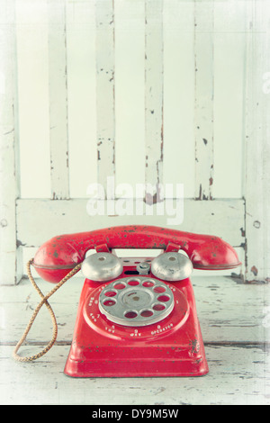 Roter Spielzeug Telefon auf leichten blauen Holzstuhl mit Vintage bearbeiten Stockfoto