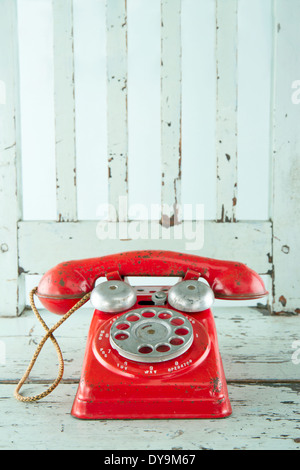 Roter Spielzeug Telefon auf leichten blauen Vintage Holzstuhl Stockfoto