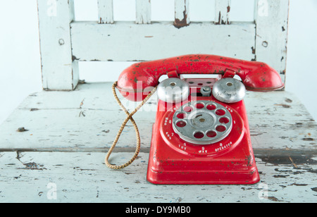 Roter Spielzeug Telefon auf leichten blauen Vintage Holzstuhl Stockfoto