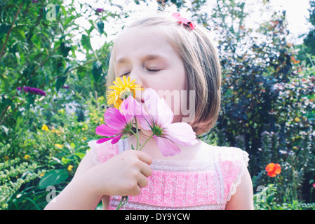 Kleines Mädchen riechende Blume Stockfoto