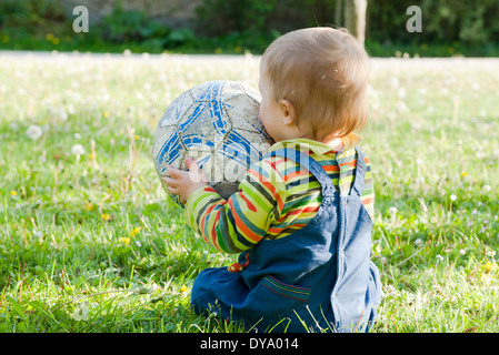 Baby-sitting auf Rasen spielen mit Fußball, Rückansicht Stockfoto