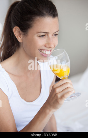 Junge Frau Glas Orangensaft trinken Stockfoto