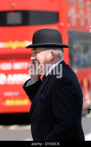 London, England, Vereinigtes Königreich. Stadt Gent eine Melone auf dem Handy auf der Straße Stockfoto