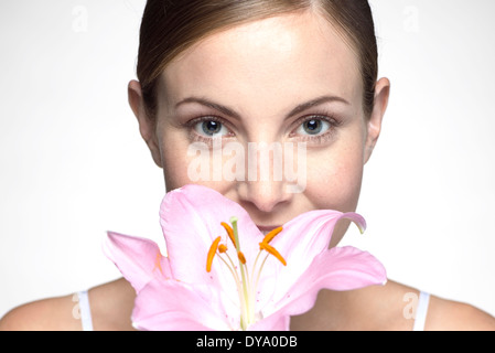 Junge Frau duftende Orchidee Stockfoto