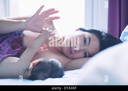 Mutter mit Baby, auf Bett liegend Porträt Stockfoto