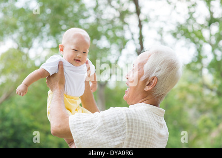 Asiatische chinesische Opa und Enkel, die Spaß am Garten. Stockfoto