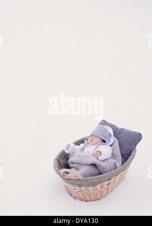 Baby schläft im Stubenwagen im Schnee Stockfoto