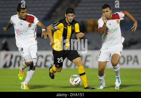 Montevideo, Uruguay. 10. April 2014. Gabriel Leyes (C) von Uruguays Penarol wetteifert den Ball mit Carlos Lujano (L) und Diego Araguainamo von Venezuelas Deportivo Anzoategui während einer Copa Libertadores match im Stadion Centenario in Montevideo, der Hauptstadt von Uruguay, am 10. April 2014. © Nicolas Celaya/Xinhua/Alamy Live-Nachrichten Stockfoto