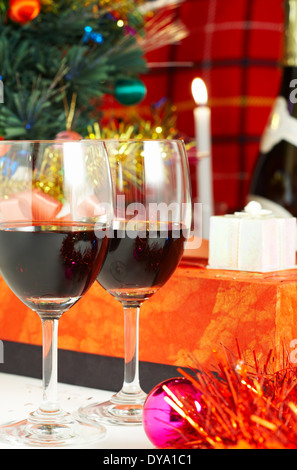 zwei Gläser mit Rotwein, Weihnachtsbaum, Kerzen und Geschenke Stockfoto