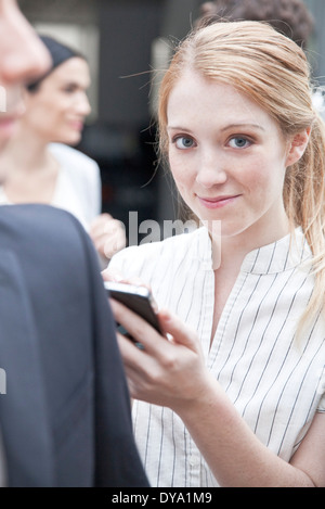 Busimesswoman Überprüfung Smartphone unterwegs Stockfoto