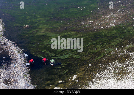 Frauen, gekleidet in traditioneller Kleidung arbeiten mit gefärbten Stoffe am Ufer des Flusses Duliu in Congjiang, Guizhou, China Stockfoto