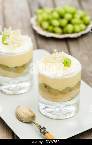 Stachelbeere Kleinigkeit, Stachelbeeren in Schüssel im Hintergrund, Holunder, Dessert, Stockfoto