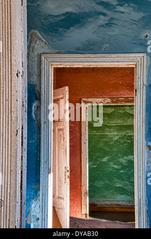 Bunte Wände und offene Türen, Zimmer voller Sand in Kolmanskop, eine Geisterstadt Bergbau in Namibia, Afrika. Stockfoto