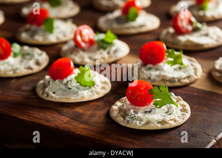 Cracker und Käse Hors d ' oeuvres mit Tomaten und Petersilie Stockfoto