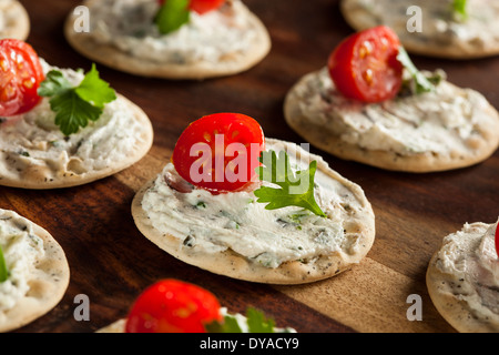 Cracker und Käse Hors d ' oeuvres mit Tomaten und Petersilie Stockfoto