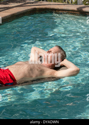 Reifen Sie Mann faulenzen im Pool, Punta Gorda, FL Stockfoto