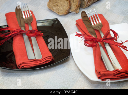 Gabeln und Messer mit roten Serviette auf Platten liegen Stockfoto