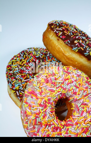 Donuts mit Zuckerguss und Streusel auf weißem Hintergrund Stockfoto