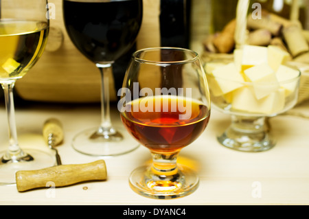 Rot- und Weißwein in Gläser Schnaps. Auf dem Hintergrund eines Fasses und Weinkorken Korb Schale mit Käse und eine Flasche gewinnen Stockfoto