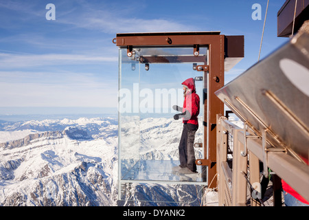 Ein Tourist steht im Feld "Schritt ins Leere" Glas auf die Aiguille Du Midi (3842m) Berggipfel über Chamonix Mont-Blanc Stockfoto