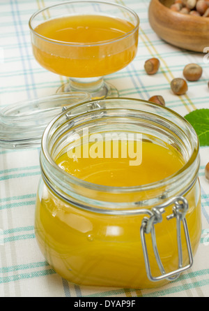Honig in einem Glas auf einem karierten Tischdecke. Stockfoto