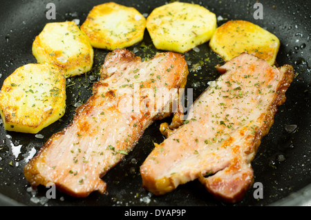 Speck und Kartoffeln in einer Pfanne gebraten. Stockfoto