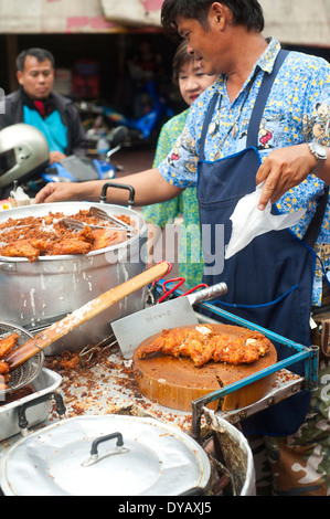 Bangkok, Thailand - Mann, der auf dem Lebensmittelmarkt in Chinatownn gebratenes Hühnchen verkauft Stockfoto