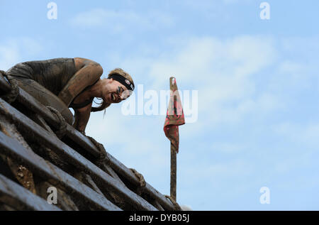 München, Deutschland. 12. April 2014. Ein Teilnehmer des "Spartan Race" steigt ein Hindernis bei der Olympiapark in München, Deutschland, 12. April 2014. Die Teilnehmer mussten zahlreiche Hindernisse auf der Strecke durch das Rennen zu überwinden. Foto: Andreas Gebert/Dpa/Alamy Live-Nachrichten Stockfoto