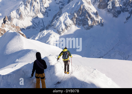 Bergsteiger steigen von einem Aussichtspunkt auf die Aiguille Du Midi (3842m) Berggipfel über Chamonix Mont-Blanc. Stockfoto