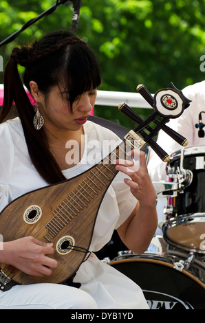 Mädchen spielen chinesisches Saiteninstrument am Faschingsdienstag, Bestandteil der Edinburgh Jazz und Blues Festival im Juli 2013. Stockfoto