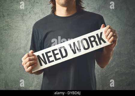 Man needs a job. Unemployed man holding board with title NEED WORK Stockfoto