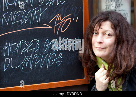 Pferdegulasch mit Klößchen. Sonderangebot. Restaurant U Zavesenyho Kafe Prag Mala Strana Street Woman at Street Chalkboard Menü mit Gerichten Stockfoto