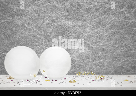 White Party Luftballons, Partydekoration und Konfetti auf einer weißen Tischdecke Stockfoto