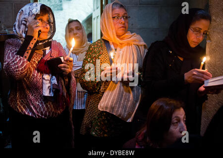 Jerusalem, Nahost. 13. April 2014. Östliche orthodoxe Christen halten Kerzen, wie sie Teil im Gebet und Prozessionen in der Kirche des Heiligen Grab am Palmsonntag statt. Stockfoto